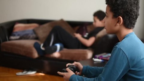 The boys play video games at home. Modern children spend time playing gadgets. Free time for kids. Children playing console. 