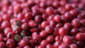 Close up footage of red peppercorns in wooden bowl. Selective focus.