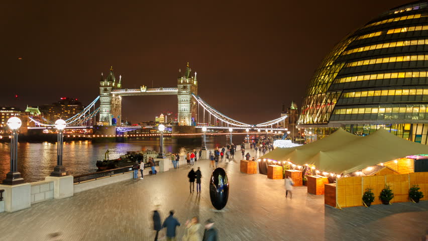 LONDON, circa 2018 - Night-time panning timelapse shot of Tower Bridge, City Hall and The City in London, England, UK