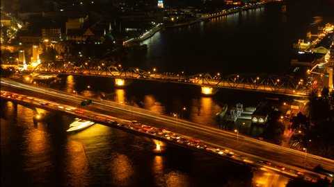 Time lapse of Memorial Bridge and Phra Pok Klao Bridge with Chao Phraya River in transportation concept, urban city at night, Bangkok, Thailand