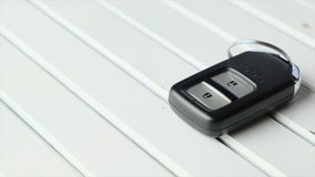 Keyless car remote control on wooden white board.