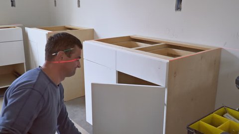worker installing kitchen cupboard