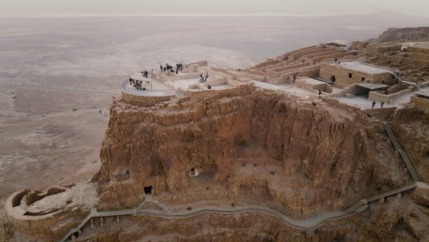 Soaring aerial 4K view MASADA, ISRAEL. Filmed flying drone. flying around Masada, an ancient Jewish fortress in the Israeli desert. Israeli soldiers on top of the mountain.