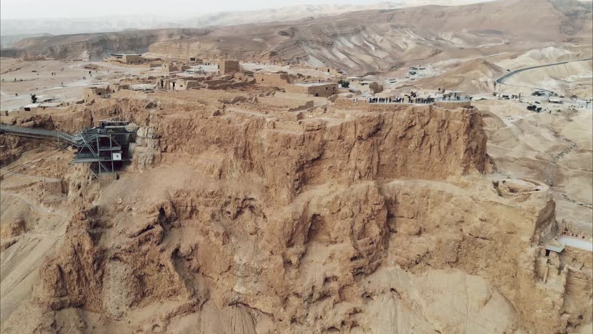 Masada - Aerial footage of the ancient fortification in the Southern District of Israel. Moving forward. Flying around Masada. The view from the top. Tourists walk among the ruins. 4k
