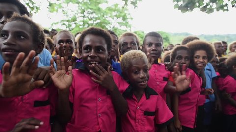 Rabaul, Papua New Guinea - 05 19 2017: Close Up Panning Shot Of Large Group Of Children Waving In Rabaul Papua New Guinea