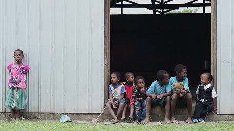 Vanimo, Papua New Guinea - 05 19 2017: Slow Motion Group Of Children Sitting In Doorway In Vanimo Papua New Guinea