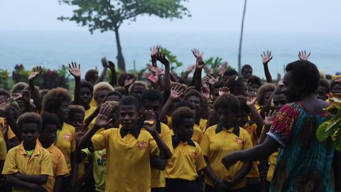 Rabaul, Papua New Guinea - 05 19 2017: Slow Motion Group Of Children In The Rain Waving At Camera In Rabaul Papua New Guinea