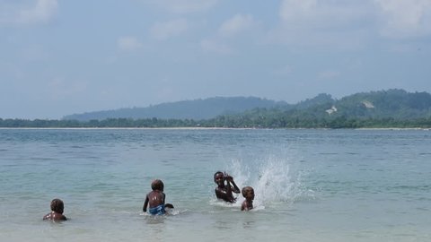 Vanimo, Papua New Guinea - 05 19 2017: Slow Motion Kids Playing And Splashing At Beach In Vanimo Papua New Guinea