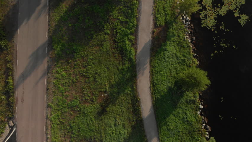 Flying over a rural road with a cyclist.