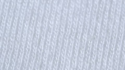 Textile background - white 100 cotton cloth with jersey (stockinette) structure. Weave pattern of threads close up.