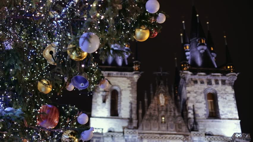 Prague, Czech Republic - December 2018: Old Town Square Christmas tree close up with Gothic Church at night. 4K resolution