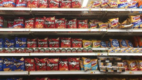DAYTON, OHIO - DECEMBER 10: Grabbing bag of Doritos at grocery store chip section on December 10, 2018 in Dayton, Ohio.