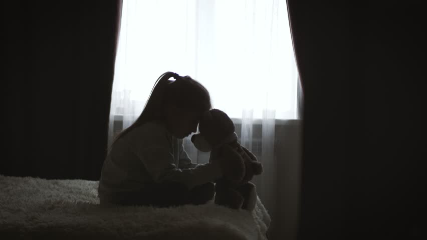 Depressed little girl hugging teddy bear. | Shutterstock HD Video #1021458019
