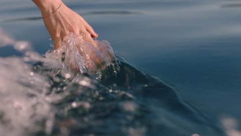 close up woman hand touching water waves splashing tourist enjoying boat rideの動画素材