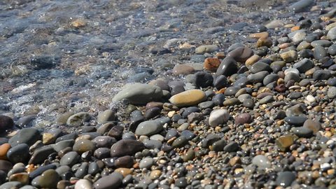 Closeup of a stony beach on a sunny day.