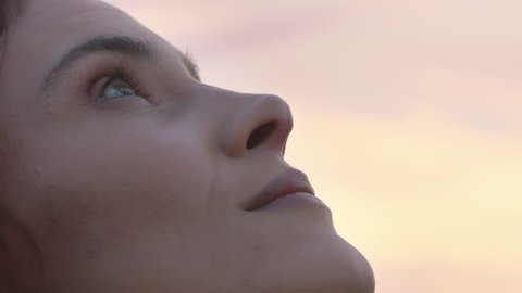 close up portrait of beautiful woman exploring spirituality looking up praying contemplating journey with wind blowing hair in countryside enjoying peaceful sunset