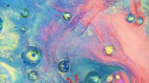 Colorful sparkling paints mix in beautiful patterns. Oil ink of blue, red, orange, yellow and other colors spread on the surface and mix one into another creating amazing textures and design.