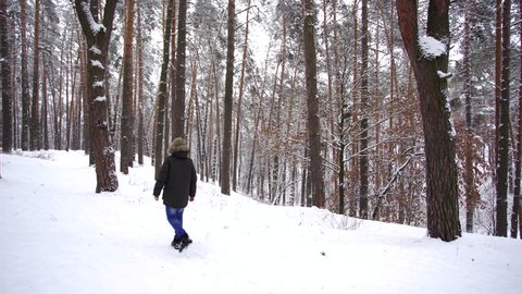 Cute kid have walk outside in beautiful snowy wood landscape. Christmas snowy magic weather. Real time 4k video footage.