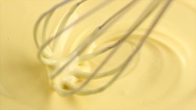 White Chocolate. Mixing melted liquid premium white milk chocolate with a whisk. Close up of liquid hot chocolate swirl. Confectionery. Confectioner prepares dessert, sauce. 4K UHD video, slow motion