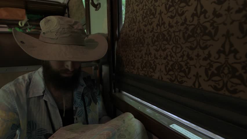 4K hipster checking map travelling on vintage train