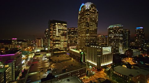 North Carolina Charlotte Aerial Flying through downtown building cityscape at dusk toward stadium 10/17