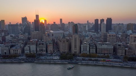 China Shanghai Aerial v47 Hyperlapse flying low over Huangpu river with waterfront view with sun setting in backdrop 10/18