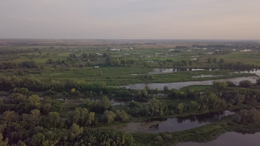 Backwater aerial view - green landscape with lake and river branch and girt, fishing and huntuing place