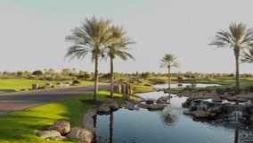 Drone footage from a golf course near a residential neighborhood in Arizona. Low shot of a water hazard near the course.