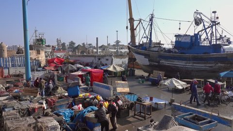 ESSAOUIRA, MOROCCO - CIRCA FEB 2018: People in the market of the fishing port of Essaouira selling their products