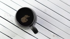Top view of coffee drink in a mug on a wooden white board. Tracking shot.