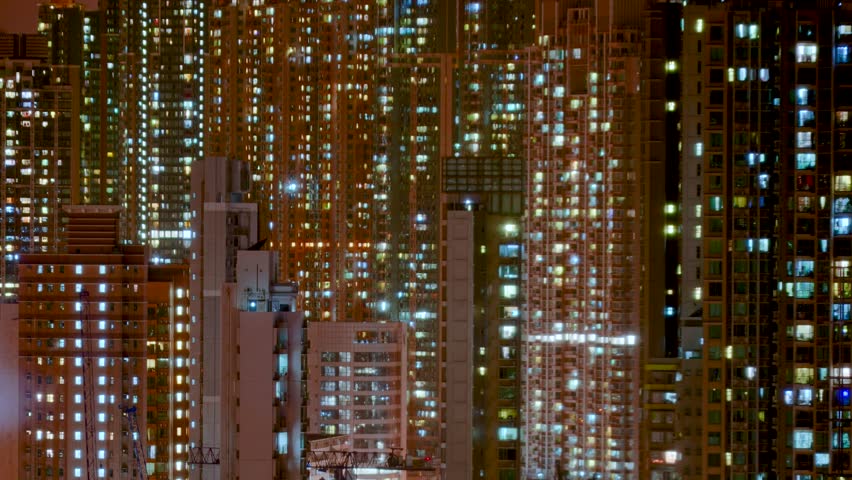 Day to night transition timelapse of Hong Kong apartment buildings. Chinese crowded city with lights turning on and off at midnight. Fast paced modern Asian night-scape time lapse in urban metropolis