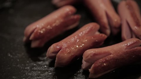 Sausages Frying on metal pan in close up view 