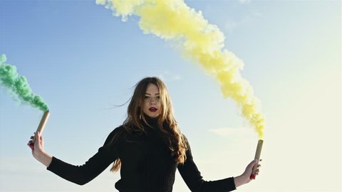 Woman makes emergency flare signal. Hipster girl with smoke bomb