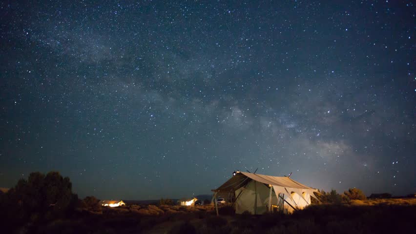 Cinemagraph time lapse of stars over camping tents in wilderness