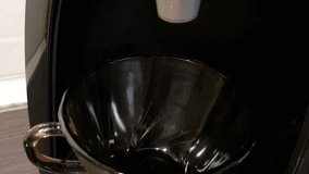 Coffee is poured into a cup of coffee machine, close-up