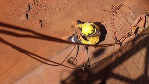 Safe work practices topeview 4K high quality footage of rope access welder worker wearing full safety harness equipment disconnecting secondary safety backup device in the safe manner Australia   