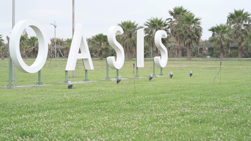 "4K young man Taking pictures of giant OASIS sign"