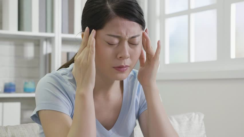 slow motion of stress housewife at home. asian woman using hands massage head suffering from headache. young girl painful body hurt resting on couch looks uncomfortable. Royalty-Free Stock Footage #1021546207