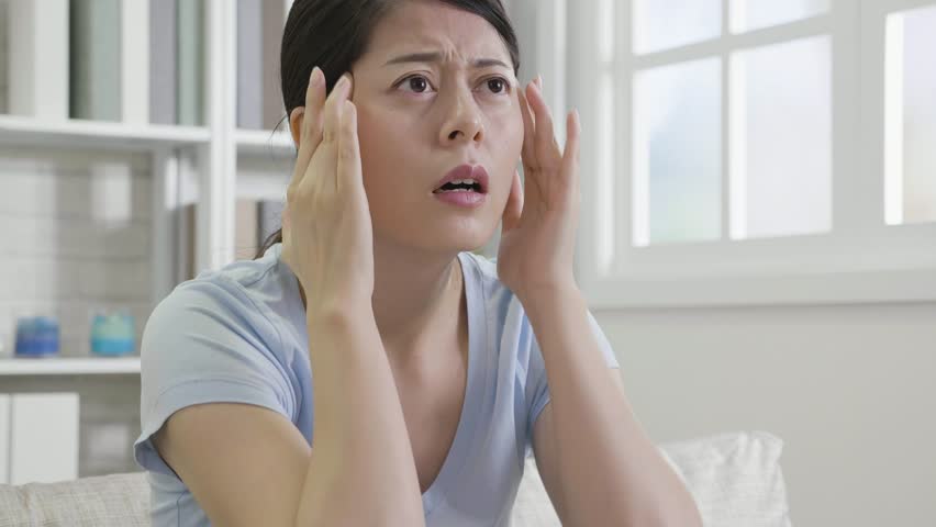 Slow motion of stress housewife at home. asian woman using hands massage head suffering from headache. young girl painful body hurt resting on couch looks uncomfortable. | Shutterstock HD Video #1021546207