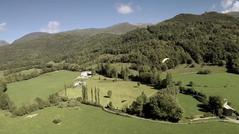 Great aerial shot of a paraglider flying over fields and hills. Beautiful natural day light. Spain. HD
