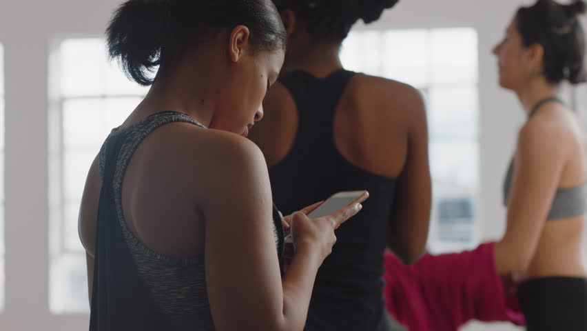 yoga class of beautiful healthy women getting ready to leave fitness studio after training practice