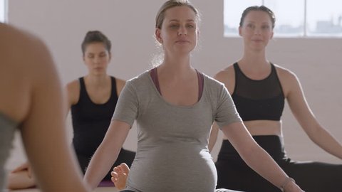 young pregnant caucasian woman in yoga class practicing stretching exercises enjoying group fitness workout at sunrise healthy lifestyle commitment