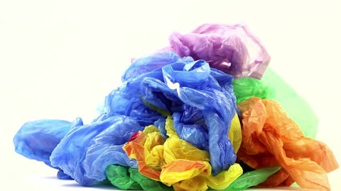 Coloured disposable plastic garbage bags open up on a white background