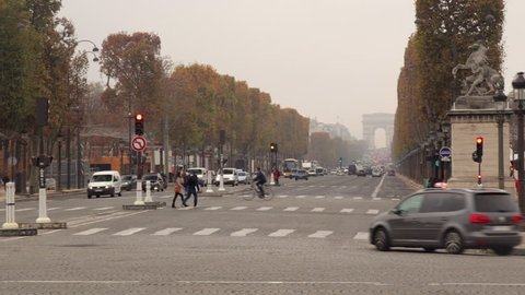 Paris, France - October 2015 : the Champs-Elysees Avenue in Paris France, in the Fall with autumn leaves, with traffic and the Arc de Triomphe in the background