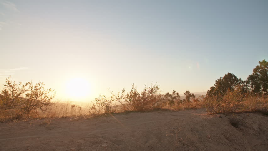 Cool mountain biker jumping at sunset, speeding up the trail, rushing down off road. Getting away from it all - activity, extreme