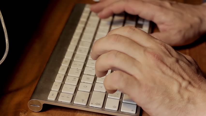 Hands of a Man Typing on A Wireless Keyboard. Close Up.