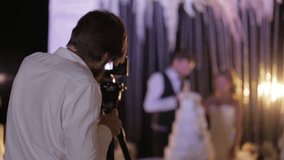 Image of movie shooting or photographing on Wedding day. Video production with camera equipment at indoor location. Loving wedding couple the bride and groom on the background, blur place for text
