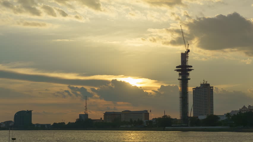 A dramatic sunset time lapse before raining coming with a small city located nearby the river.