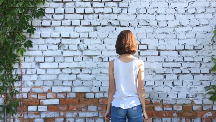 Teenager girl with two paper hearts. She wriggles around herself, laughs and has fun.