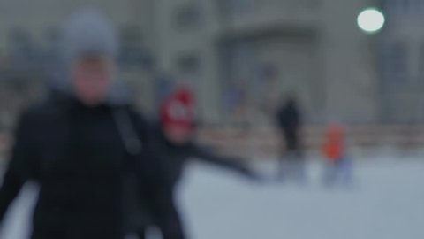 People ice skating. Ice skating rink. Defocused